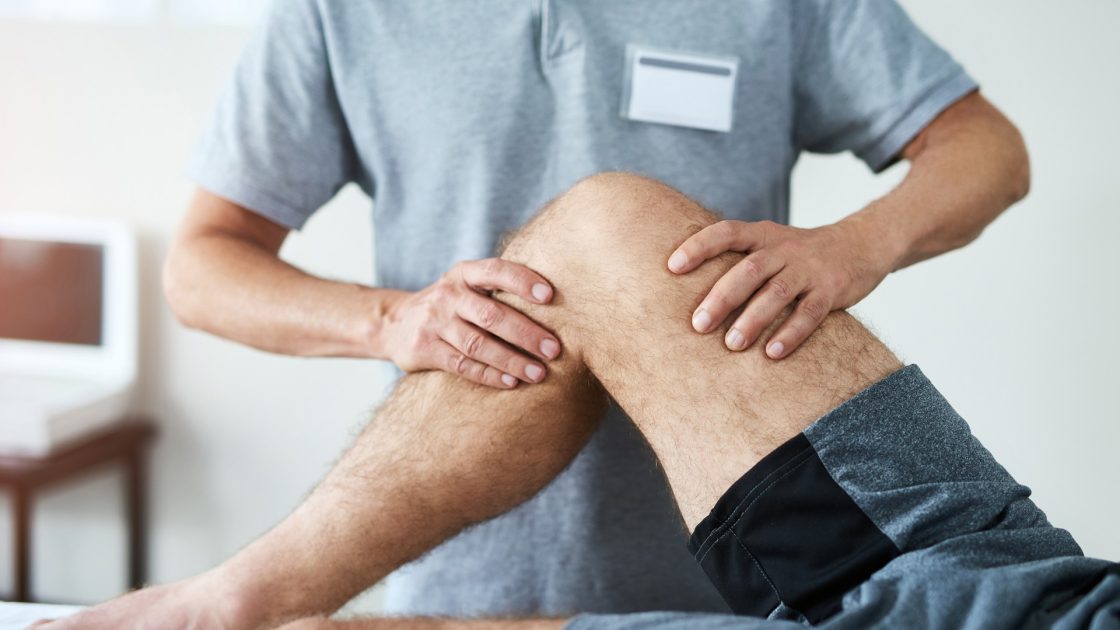 HCPC-registered physiotherapist examining a patient's knee during an ACL assessment in Preston