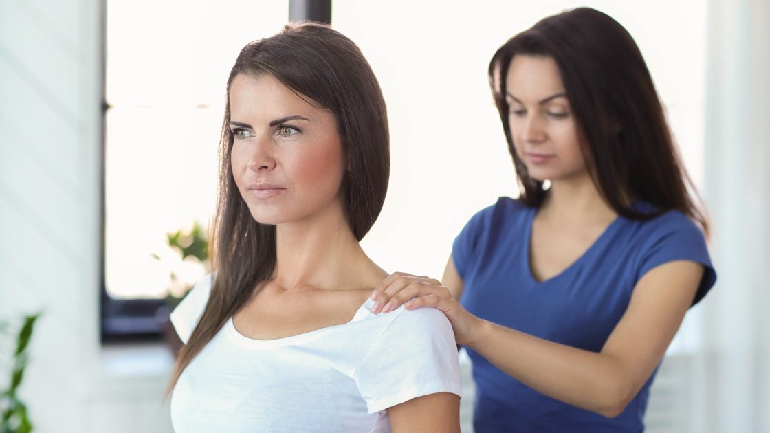 HCPC-registered physiotherapist assessing a patient's shoulder for frozen shoulder treatment in Preston